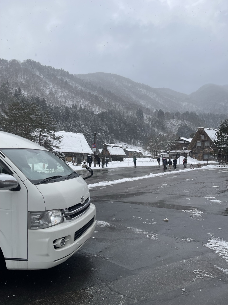 雪景色の村でのキャンピングカー
